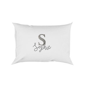 May include: White pillow with a silver glitter letter "S" and the name "Sophie" embroidered in black.