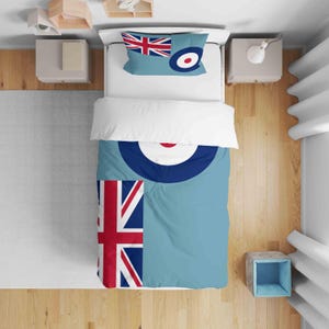 May include: A light blue duvet cover and pillowcase set with a Union Jack flag and roundel design. The bedding is on a white bed. The pillowcase features the Union Jack flag and roundel. The duvet cover has a large roundel.