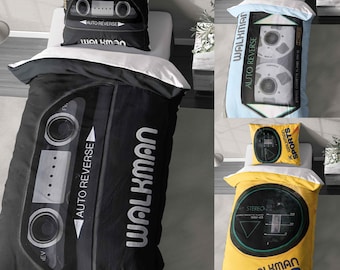 Op de afbeelding: Beddengoedsets met cassettebandontwerpen. Eén set is zwart met de tekst "Walkman" en "Auto Reverse". Een andere is lichtblauw met een cassettebandafbeelding. Een derde is geel met de tekst "Walkman Sports".