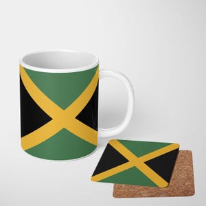 May include: A white ceramic coffee mug and a square coaster featuring the Jamaican flag design. The flag design includes a black cross over green and yellow sections. The coaster is on a cork base.