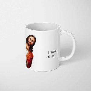 May include: White ceramic mug with an image of Jesus Christ peeking from behind the mug. The text "I saw that" is printed on the mug in black. The mug has a curved handle.