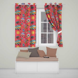 May include: A pair of red curtains featuring a repeating pattern of colourful camper vans, acoustic guitars, cameras, palm trees, suns, and flowers. The curtains are hung on a white rod and are positioned over a window with a view of a city.