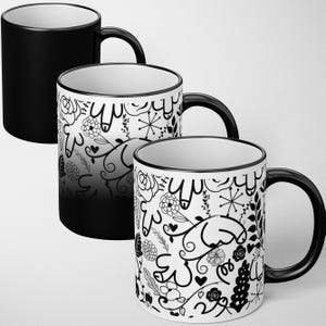 May include: Three ceramic mugs with black handles and rims. One mug is solid black, while the other two feature a white background with a black floral and abstract design. The mugs are designed for hot beverages.