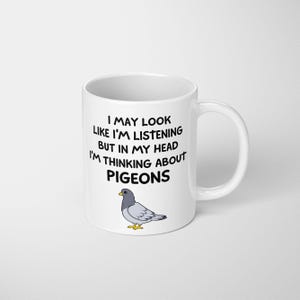 May include: White ceramic mug with black text: "I may look like I'm listening but in my head I'm thinking about pigeons." A cartoon pigeon is below the text. The mug has a white handle.