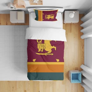 May include: A bed set featuring the flag of Sri Lanka. The duvet cover and pillowcase display the flag's maroon background with a golden lion holding a sword, and orange and green stripes. The pillowcase also has a vertical stripe.