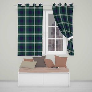 May include: Two window curtains featuring a dark green, navy blue, and white plaid pattern with silver grommets at the top. The curtains hang on a white rod, with one panel pulled to the side, revealing a window view of a city building.