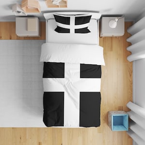 May include: A black and white bedding set with a cross pattern. The set includes a duvet cover and pillowcases. The bed has a white sheet and is surrounded by wooden flooring and a grey rug. The duvet cover measures approximately 200cm x 200cm.