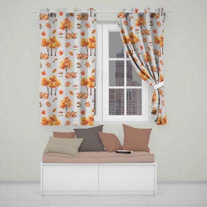 May include: Two white curtains featuring a repeating pattern of orange foxes, yellow and orange autumn trees, and small mushrooms. The curtains are hung on a silver rod with grommets, positioned above a white bench with several solid-coloured pillows.