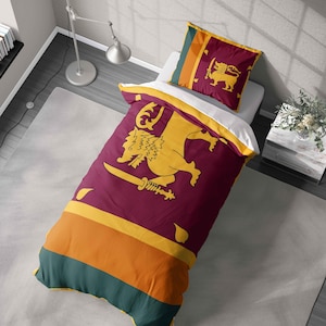 May include: A bed set featuring the flag of Sri Lanka. The duvet cover and pillowcase display a maroon background with a golden lion holding a sword. The design includes yellow, orange, and green stripes.