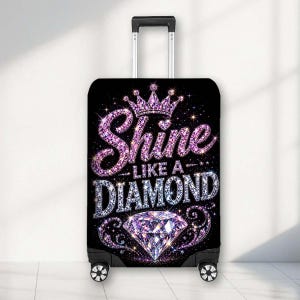 May include: A black suitcase cover featuring a purple glitter crown above the text Shine Like A Diamond in purple and white sparkling diamond-style lettering, with a large faceted diamond graphic at the bottom and decorative swirling accents.