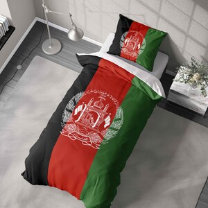 May include: Bedding set with the flag of Afghanistan design. The duvet cover and pillowcase show the flag's black, red, and green stripes, with the national emblem in white. The bedding is made of a soft, likely synthetic material.