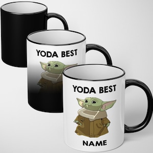 May include: Three white ceramic mugs with black handles and rims. Each mug features a cartoon image of Grogu, also known as Baby Yoda, and the text "YODA BEST". One mug is black. The bottom mug has the text "NAME".