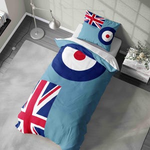 May include: A light blue duvet cover and pillowcase set. The duvet cover features a large blue, white, and red bullseye design, with a Union Jack flag in the corner. The pillowcase has a Union Jack flag and bullseye.