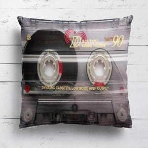 May include: A cushion with a retro cassette tape design. The clear plastic case reveals the tape reels and internal components. Text includes "IEC I/TYPE I NORMAL POSITION" and "DYNAMIC CASSETTE LOW NOISE HIGH OUTPUT".