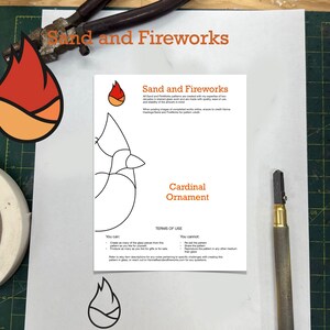 K&ouml;nnte beinhalten: Ein druckbares Muster f&uuml;r einen Kardinal-Anh&auml;nger mit Anweisungen zum Erstellen eines Glasobjekts mit der "Sand and Fireworks"-Methode. Das Muster ist in Schwarz auf wei&szlig;em Hintergrund umrandet. Der Text "Sand and Fireworks" und "Cardinal Ornament" ist orange.