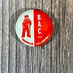 Peut inclure: Un bouton rouge et blanc avec la silhouette d'un enfant avec une canne et le texte "B.A.C. Pour Enfants Handicapés".