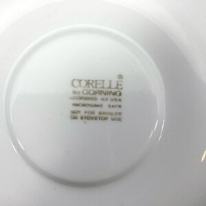 Puede incluir: Plato blanco con el texto "CORELLE by CORNING CORNING BY USA MICROWAVE SAFE NOT FOR BROILER OR STOVETOP USE" impreso en la parte inferior.