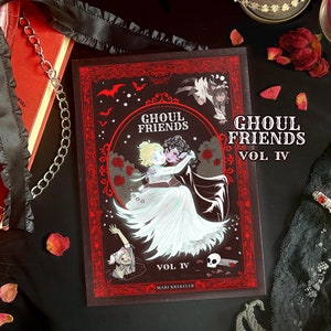 May include: A red and black book with a gothic design. The book is titled "Ghoul Friends Vol IV" and features an illustration of two figures in a spooky setting. The book is on a black surface with red rose petals.