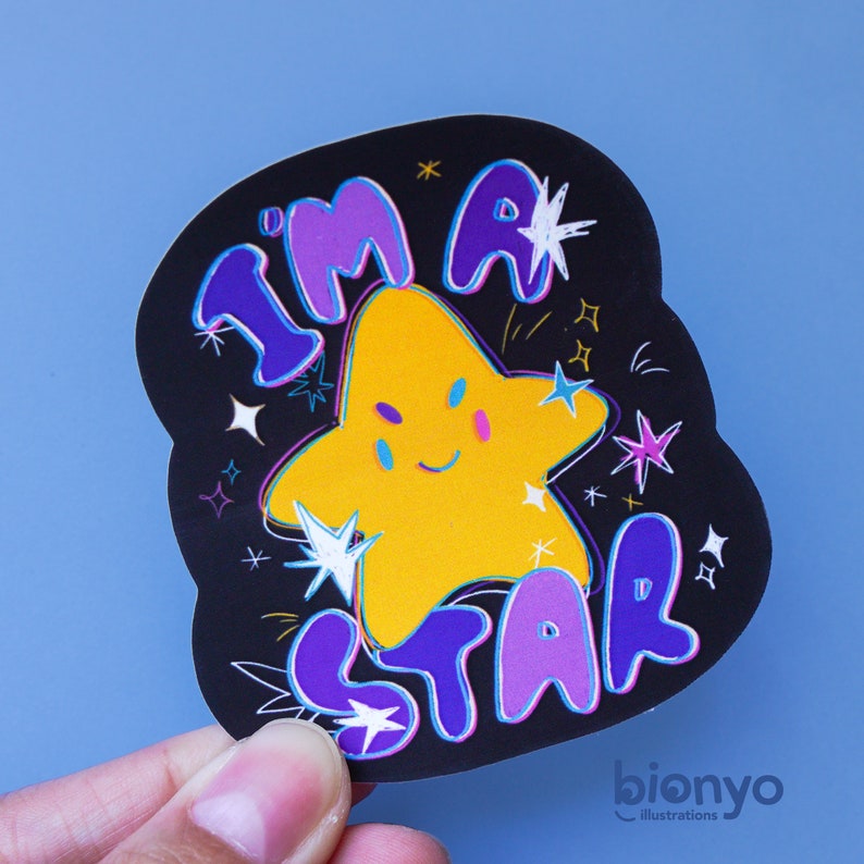 May include: A black and purple sticker with a yellow star in the center. The star has a smiling face and is surrounded by white and purple stars. The text "I'm a star" is written in purple and white letters around the star.