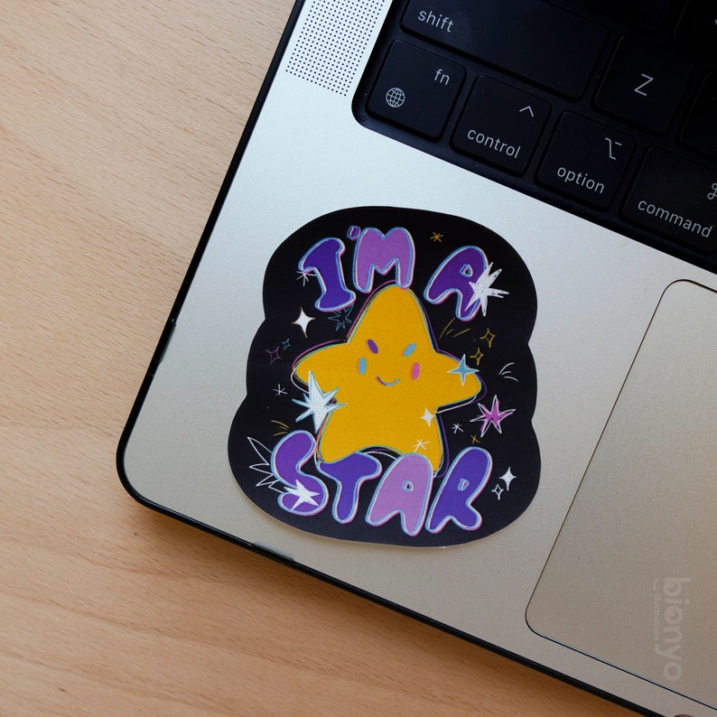 May include: A black and purple sticker with a yellow star and the text "I'm a Star" on a laptop.