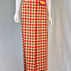 May include: A red and brown checked skirt with a button-up front. The skirt is knee-length and has a high waist. The skirt has a tag that says "Very Precious".