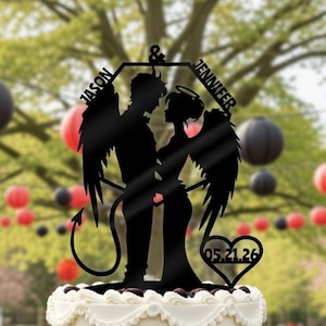Puede incluir: Una tarta de boda de dos pisos con glaseado negro y blanco, coronada con un adorno para tarta de silueta negra. El adorno presenta una pareja con alas de ángel y cola de diablo, con los nombres "Jason & Jennifer" y la fecha "05.21.26".