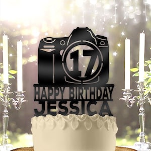 May include: Black acrylic cake topper with a camera silhouette, the number 17 inside a circle, and the text "Happy Birthday Jessica".