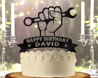 Peut inclure: Décor de gâteau noir avec une main tenant une clé et une bannière qui dit "Joyeux anniversaire David".