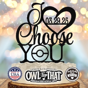 May include: Black acrylic cake topper with the text "I Choose You" and a heart with the date "03.29.25". The topper also features a black and white Pokeball graphic.