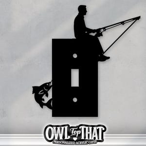 Könnte beinhalten: Schwarze Silhouette eines Anglers, der auf einer Lichtschalterabdeckung sitzt, Angelrute ausgestreckt. Ein Fisch springt von der Seite. Die Worte "OWL TOP THAT" stehen unten, darunter "PERSONALIZED ACRYLIC GIFTS".
