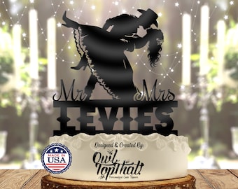 May include: Black silhouette cake topper featuring a dancing couple in cowboy attire. The topper reads "Mr & Mrs LEVIES" and is placed on a white frosted cake. The design includes the text "Designed & Created By: Owl TopThat! Personalized Cake Toppers."