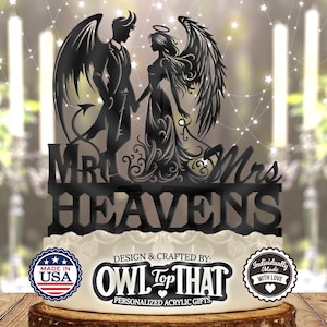 Puede incluir: Topper de pastel de acrílico negro con una silueta de un diablo y un ángel con alas, tomándose de la mano. El topper dice "Mr. & Mrs. Heavens" y está diseñado por Owl Top That.