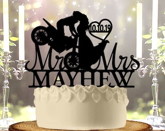 May include: Black silhouette cake topper of a couple riding a motorcycle with a heart that says "10.10.19" and the text "Mr. & Mrs. MAYHEW".