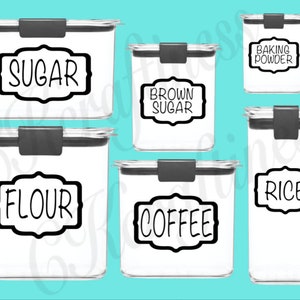 May include: Six clear plastic containers with black lids and labels. The labels are black with white text and have a decorative border. The labels read "Sugar", "Brown Sugar", "Baking Powder", "Flour", "Coffee", and "Rice".