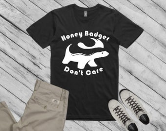 May include: Black t-shirt with a white graphic of a honey badger with the text "Honey Badger Don't Care".