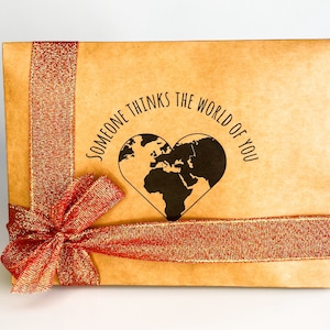 Gift box featuring a red bow with message "someone thinks the world of you" written in the middle. Perfect for showing appreciation and appreciation for a loved one.