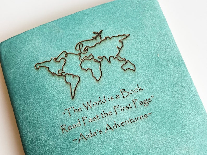 Personalized softcover Travel Journal with Name and world map design with travel quote that says 'The world is a book, read past the first page'