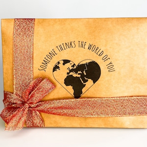 Gift box featuring a red bow with message "someone thinks the world of you" written in the middle. Perfect for showing appreciation and appreciation for a loved one