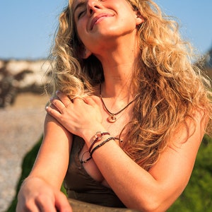 18inch beach wave necklace, shown on model sitting on the beach.