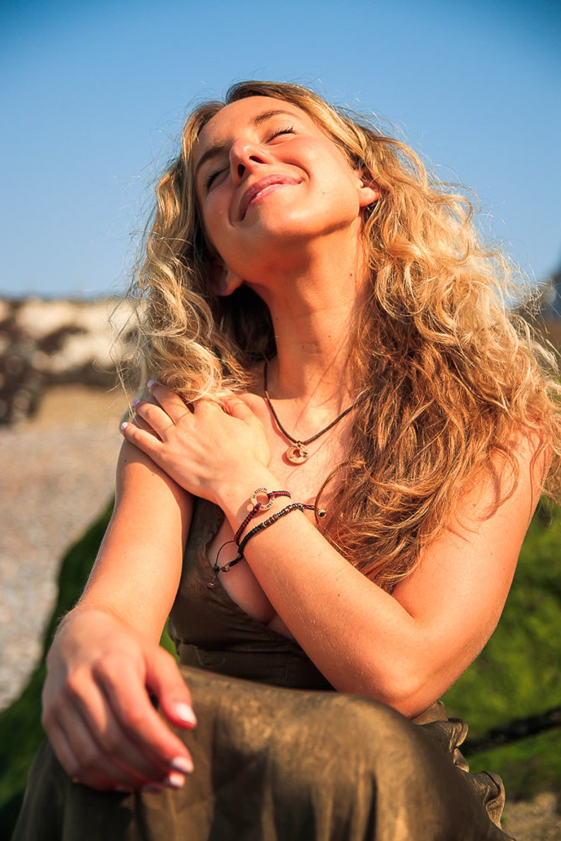 18inch beach wave necklace, shown on model sitting on the beach.