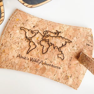 May include: Cork luggage tag with a world map design and the text "Amie's Wild Adventures".
