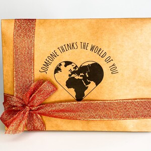 Gift box featuring a red bow with message "someone thinks the world of you" written in the middle. Perfect for showing appreciation and appreciation for a loved one.