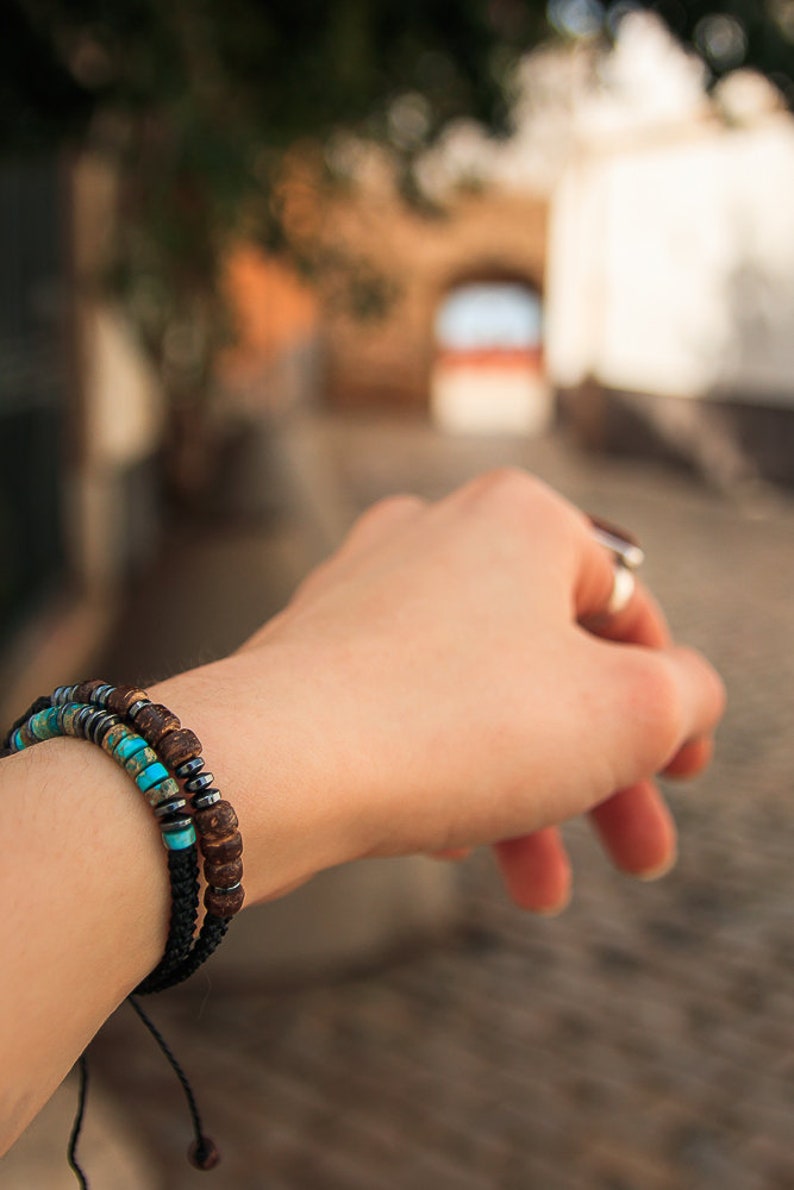 Double stacked Morse code bracelets with Turquoise and wooden beads, pictured on model's wrist with blurred street background.