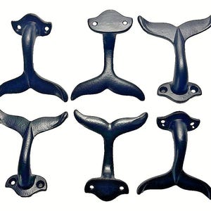 May include: Six cast iron whale tail decorative pieces in a dark blue-black color. Each piece has a unique design, with varying tail shapes and mounting bases. The pieces are arranged against a white background.