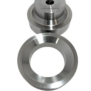 May include: Two silver metal rings, one stacked on top of the other. The top ring has a smaller hole in the center and the text "UTVDISTRIBUTION INC" is printed on the side.
