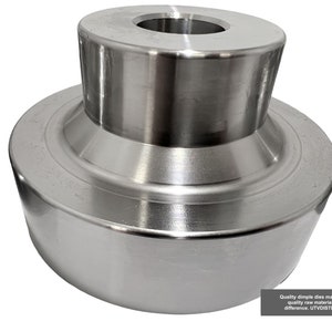 May include: A silver metal dimple die with a round top and a flat bottom. The die has a smooth, polished surface.