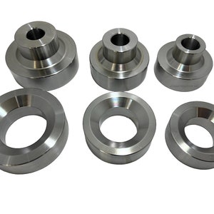 May include: Set of six silver metal spacers, some are round and some are cylindrical with a hole in the centre.