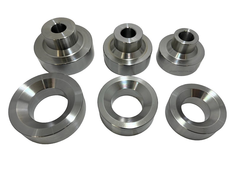 May include: Set of six silver metal spacers, some are round and some are cylindrical with a hole in the centre.