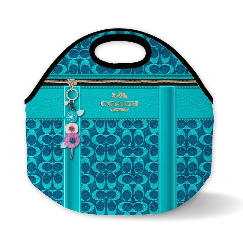 May include: A turquoise blue lunch bag with a Coach logo and a floral charm. The bag has a zipper closure and a black handle.