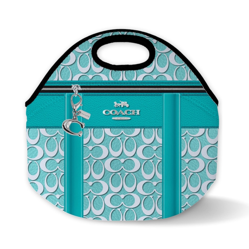 May include: A turquoise blue lunch bag with a white Coach logo and a silver charm. The bag has a zipper closure and a top handle.